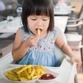 Portrait of little asian girl in fast food restaurant