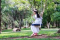 Portrait of little Asian girl playing the swing under the big tree in the nature forest select focus shallow depth of field Royalty Free Stock Photo