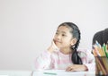 Portrait little Asian girl sitting on the chin and smile with happiness metaphor thinking someting day dreamer concept with copy Royalty Free Stock Photo