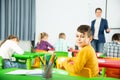 Portrait of little assiduous boy with pen and notebook at lesson in elementary school Royalty Free Stock Photo