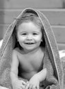 Portrait of little baby boy cover body under towel after bath. Concept of kids face close-up. Head shoot children
