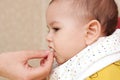 Portrait of little baby boy eating food. Baby with a spoon in feeding chair. Cute baby eating first meal