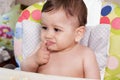 Portrait of little baby boy eating food. Baby with a spoon in feeding chair. Cute baby eating first meal