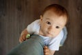 Portrait of a baby boy, embracing mother`s leg and asking to take him on hands or to talk to him Royalty Free Stock Photo