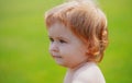 Portrait of a little baby boy playing outdoor in the grass. Baby face close up. Funny little child closeup portrait Royalty Free Stock Photo