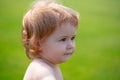 Portrait of a little baby boy playing outdoor in the grass. Baby face close up. Funny little child closeup portrait Royalty Free Stock Photo