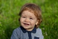 Portrait of a little baby boy playing outdoor in the grass. Baby face close up. Funny little child closeup portrait Royalty Free Stock Photo