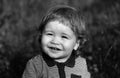 Portrait of a little baby boy playing outdoor in the grass. Baby face close up. Funny little child closeup portrait Royalty Free Stock Photo