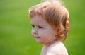 Portrait of a little baby boy playing outdoor in the grass. Baby face close up. Funny little child closeup portrait Royalty Free Stock Photo