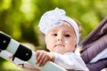 Portrait of the little baby girl sitting in a children`s carriage in summer day. Royalty Free Stock Photo