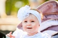 Portrait of the little baby girl sitting in a children`s carriage in summer day. Royalty Free Stock Photo