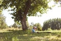 Portrait of little baby girl sitting on plaid on picnic outdoors at sunset in summer Royalty Free Stock Photo