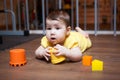 Portrait of a little baby girl teething, chewing and playing toy on floor of domestic room Royalty Free Stock Photo