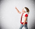 Portrait of little baby girl in white warm waistcoat and red t-shirt under the snow touching snowflakes, sticking finger Royalty Free Stock Photo