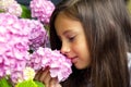 Portrait of a little beautiful girl with a bouquet of hydrangeas in her hands. Royalty Free Stock Photo