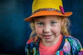 Portrait of a little beautiful girl in cowboy hat on a blue background. A fashionable young girl smiles and looks in a hat with Royalty Free Stock Photo