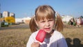 Portrait of a little beautiful Slavic girl eating ice cream in a city park in summer Royalty Free Stock Photo