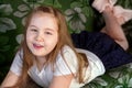 Portrait of a little beautiful smiling girl. Little cute girl lying on sofa and having outside in summer