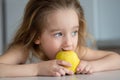 Portrait of a little blond girl smiling and eating an apple. The concept of healthy eating for children Royalty Free Stock Photo