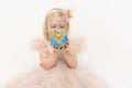 Portrait of little blonde girl serious looking on globe in hands. Child wears pink dress with puffy sleeves. Travel Royalty Free Stock Photo