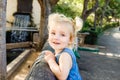 Close up Portrait of little blondy toddler Girl Smiling at Camera. Happy kid walking outdoors in the park or zoo. Family recreatio