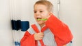 Portrait of little boy brushing and cleaning his teeth with toothbrush at bathroom. Concept of child dental hygiene and Royalty Free Stock Photo