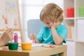 Portrait of little boy drawing something for art class