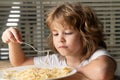 Portrait of little boy eating pasta, spaghetti. Concept of kids face close-up. Head shoot children portrait.