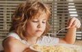 Portrait of little boy eating pasta, spaghetti. Concept of kids face close-up. Head shoot children portrait.