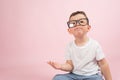 Portrait of a little boy in glasses, dressed in white t-shirt, pink background with copy space Royalty Free Stock Photo