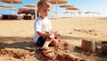 Portrait of cute little boy making sand castle on the sea beach Royalty Free Stock Photo