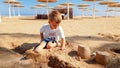 Portrait of cute little boy making sand castle on the sea beach Royalty Free Stock Photo