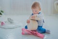 Portrait of little boy playing with empty gift box in bright white room Royalty Free Stock Photo