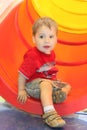 Portrait of little boy in red T-shirt near plastic tube