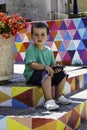 Portrait of little boy sitting on the steps and colorful wall Royalty Free Stock Photo