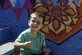 Portrait of little boy sitting on the steps and colorful wall Royalty Free Stock Photo