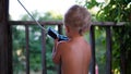 Portrait of little boy standing backward and try to talking into phone handset