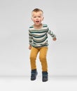 Portrait of little boy in striped shirt jumping