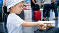 Portrait of little boy with wooden toy airplane in international airport Royalty Free Stock Photo