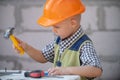 Portrait of little builder in hardhats with instruments for renovation on construction. Builder boy, carpenter kid with Royalty Free Stock Photo