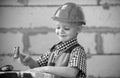 Portrait of little builder in hardhats with instruments for renovation on construction. Builder boy, carpenter kid with Royalty Free Stock Photo