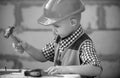 Portrait of little builder in hardhats with instruments for renovation on construction. Builder boy, carpenter kid with Royalty Free Stock Photo