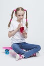 Portrait of Little Caucasian Blond Girl with Long Pigtails Posing With Pink Pennyboard Royalty Free Stock Photo