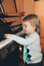 Portrait of little caucasian boy playing piano at home Royalty Free Stock Photo