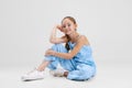 Portrait of little Caucasian cute girl calmly sitting and smiling isolated over gray studio background. Royalty Free Stock Photo