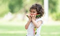 Portrait of little Caucasian cute girl holding sliced watermelon and enjoy eating or biting fresh fruit while picnic at park. Royalty Free Stock Photo