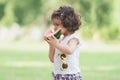 Portrait of little Caucasian cute girl holding sliced watermelon and enjoy eating or biting fresh fruit while picnic at park. Royalty Free Stock Photo