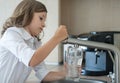 Portrait of a little caucasian girl gaining a glass of tap clean water. Kitchen faucet. Cute curly kid pouring fresh water Royalty Free Stock Photo