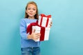 Portrait of little caucasian girl with long brow hair in blue hoody holds a white boxes with gifts  on blue Royalty Free Stock Photo