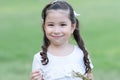 Portrait of little Caucasian girl with white t-shirt and hair tied up 2 sides is smiling looking at camera